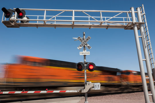 Fototapeta Zooming train engine speeding past railroad crossing