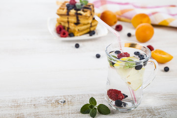 Homemade lemonade with fresh berries on a wooden table.Cocktail