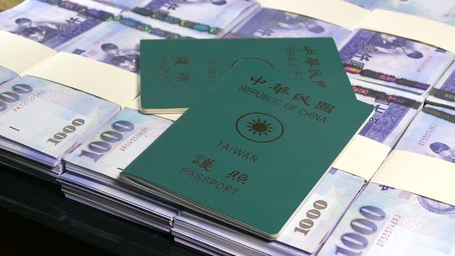 Passports thrown on stacks of thousand New Taiwan Dollars