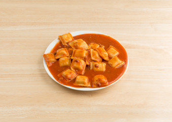 Plate of ravioli on a wood table.