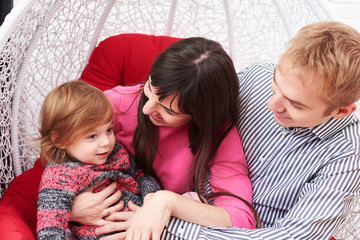 Mom holding a small daughter in arms while sitting together with