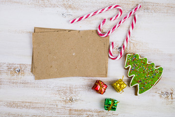Gingerbread, candy canes and cards on a wooden background. Chris