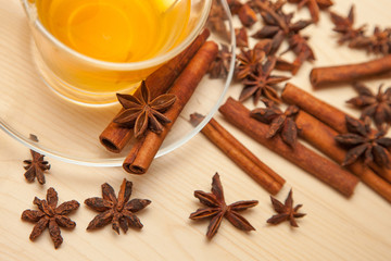 seasoning cinnamon (Cinnamomum), anise (Anisium vulgare Gaerto) and cup of tea on a light wood surface, close-up, background, healthy lifestyle