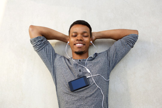 attractive man lying with cellphone listening to music