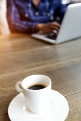 young man working on laptop with cup of coffee at table