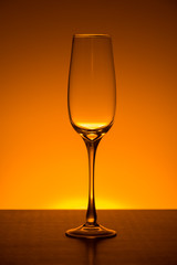 empty champagne glass on Orange gradient background