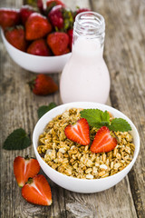 Granola with strawberry on a wooden table. Healthy eating.