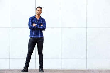 happy and confident african man standing with arms crossed