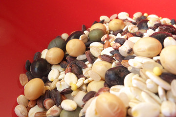 Cereals and beans on red background