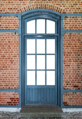 Wooden door with metal frame in a brick wall
