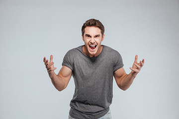 Portrait of an excited young man with both hands up