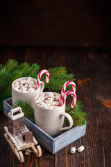 Two cups with small marshmallows on a dark wooden background