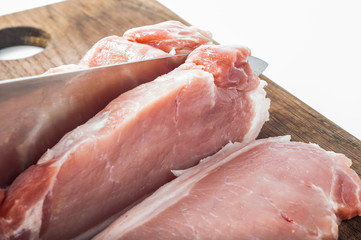 Cutting raw meat on wooden board