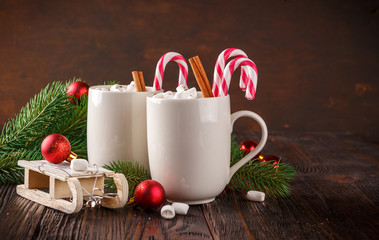 Two cups with small marshmallows on a dark wooden background