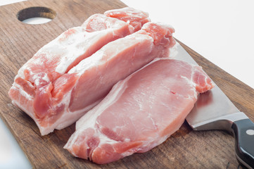 Cutting raw meat on wooden board