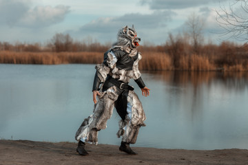 Man wolf werewolf, runs near the lake.