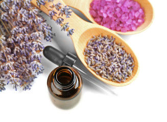 Essential oil, lavender and sea salt on white background