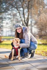 People and dogs outdoors. Beautiful and happy girl enjoying in autumn park walking with her Dog..Colored photo