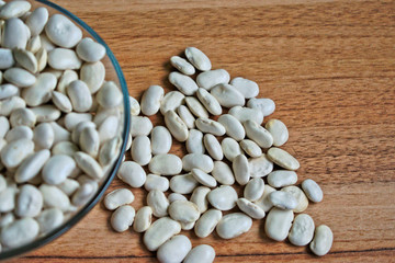 White beans in a bowl on a wooden table