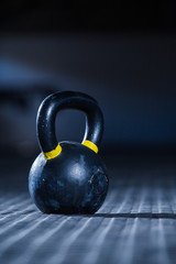 Obraz na płótnie Canvas Kettle bell weight in a dark gym with moody and edgy lighting