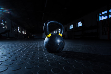 Naklejka na ściany i meble Kettle bell weight in a dark gym with moody and edgy lighting
