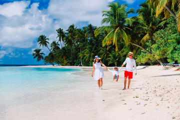 family with kid playing on tropical beach