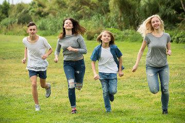 Obraz premium Teenagers running on green lawn in park .