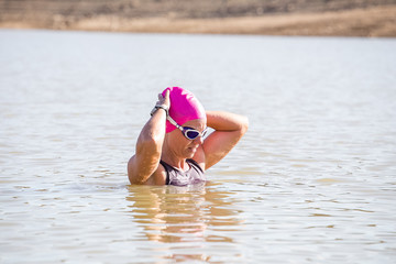 Female triathlete swimming in a dam while competing in a triathlon