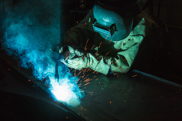Welder of Metal Welding with sparks and smoke in  manufacturing