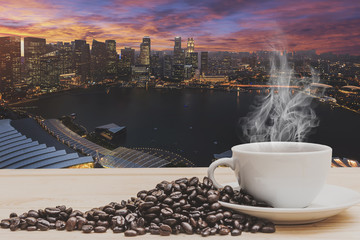 Coffee on wooden table with Singapore city in sunset time