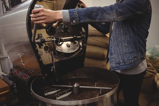 Man using grinding machine in coffee shop
