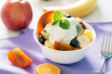 Bowl of healthy fresh fruit salad with youghurt