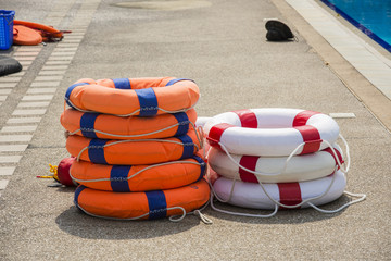 ring buoy orange and white be side the pool