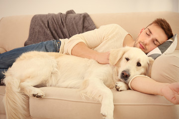 Handsome man with cute dog sleeping in sofa
