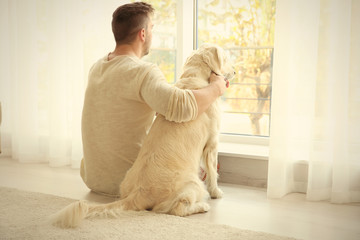 Handsome man with cute dog at home
