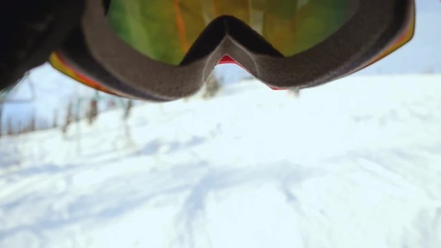 Skier wearing glasses on the background of sky with sun and mountains in slowmotion. 1920x1080