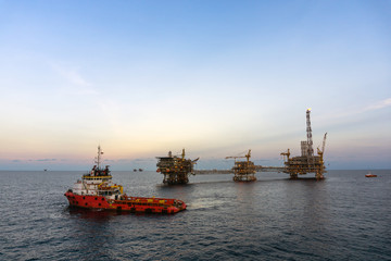 Obraz premium A tug boat performing anchor handling task at oil field