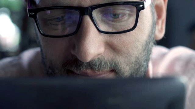 Young man browsing photos on tablet computer
