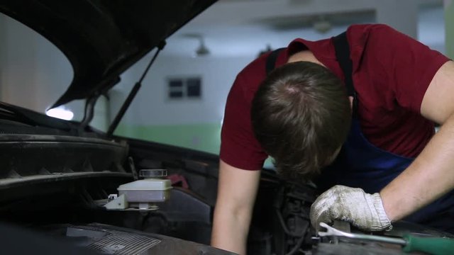 man repair under the hood of car