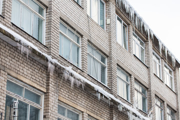 Fototapeta na wymiar icicles on building or living house facade