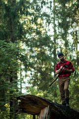 portrait of a man - lumberjack with an ax in the forest, front view