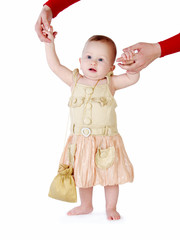 Little girl learns to walk, taking its first steps. Female hands mother support the child