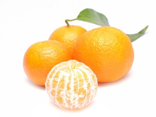 Ripe mandarin with leaves close-up on a white background.