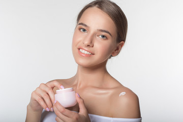 Girl is holding jar with moisturizing cream