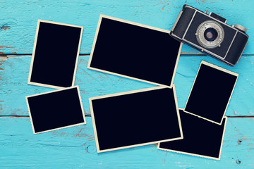 Top view of empty photo frames next to old camera