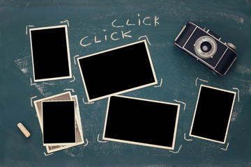 Top view of empty photo frames next to old camera
