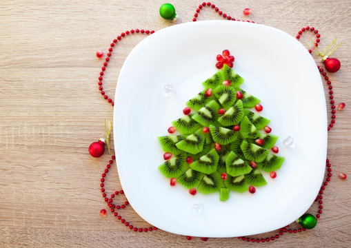 Kiwi Christmas tree - fun food idea for kids party or healthy breakfast, beautiful New Year food background