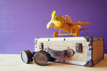 vintage toy plane and old suitcase next to pilot glasses