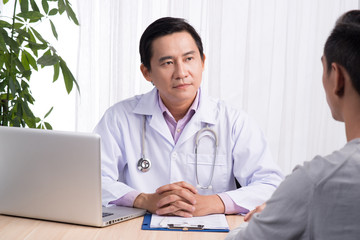 Fototapeta na wymiar Confident asian male doctor discussing diagnosis with patient in