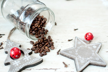 Wooden Christmas toys on the table. Tree, star, cloves and spilled coffee beans from a jar. Rustic Christmas background.